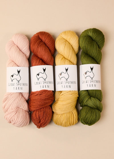 Four skeins of hand-dyed Australian merino yarn in various colors, ideal for DK weight projects.