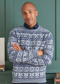 A man in a cozy sweater featuring a detailed geometric knit pattern in shades of blue and gray, exuding warmth and style.