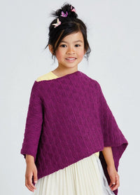Smiling child wearing a purple textured poncho over a yellow top and a white skirt. Her hair is styled with pink and white butterfly clips.