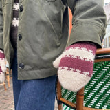 A person wearing knitted mittens, showcasing the intricate design and craftsmanship of the Key Mittens.