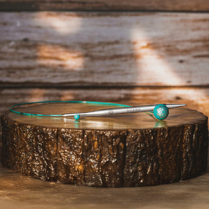  A wooden table features a blue knitting cable on its surface, emphasizing a neat and uncluttered appearance.