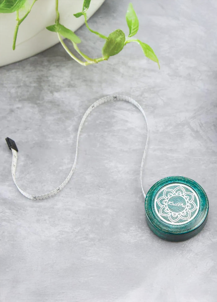 A green and white circular tape measure featuring a white flower at the center, showcasing a delicate and elegant design.