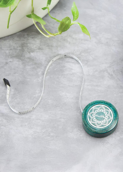 A green and white circular tape measure featuring a white flower at the center, showcasing a delicate and elegant design.