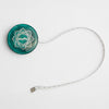  Teal wooden tape measure with a green button, white cord, and gold lotus design, part of the Mindful Collection accessories.