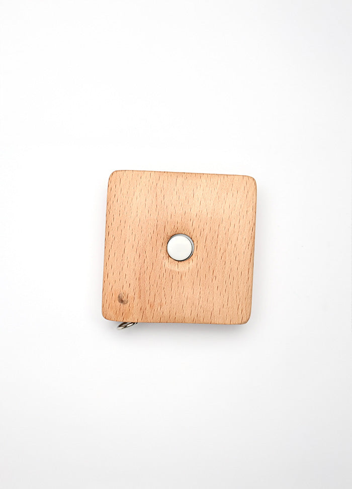 Square beechwood tape measure with sheep designs, 150cm/60" long, retractable via a button in the center.