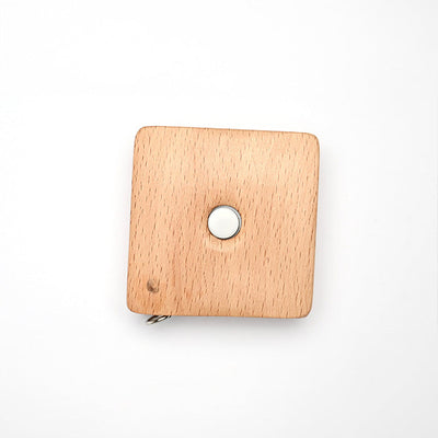 Square beechwood tape measure with sheep designs, 150cm/60" long, retractable via a button in the center.