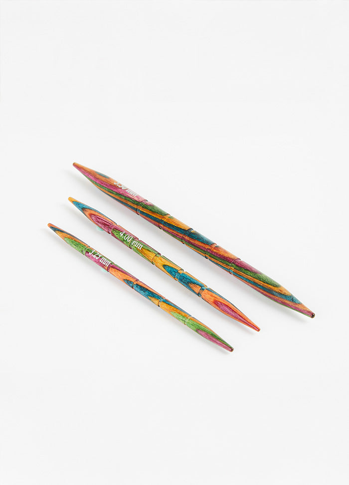 Three colorful Symfonie wood knitting needles with grooves, available in sizes 3.25mm, 4.00mm, and 5.50mm.