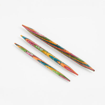 Three colorful Symfonie wood knitting needles with grooves, available in sizes 3.25mm, 4.00mm, and 5.50mm.