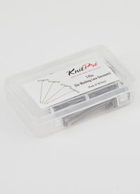 A plastic container featuring T-pins, designed for pinning lace shawls to create elegant scalloped edges