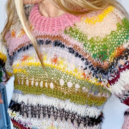 Close-up of a person wearing a loosely knit, multicolored sweater with horizontal stripes in pink, green, yellow, white, black, and brown. The open-weave design creates a semi-transparent effect, showcasing the book’s bold and expressive knitting style.