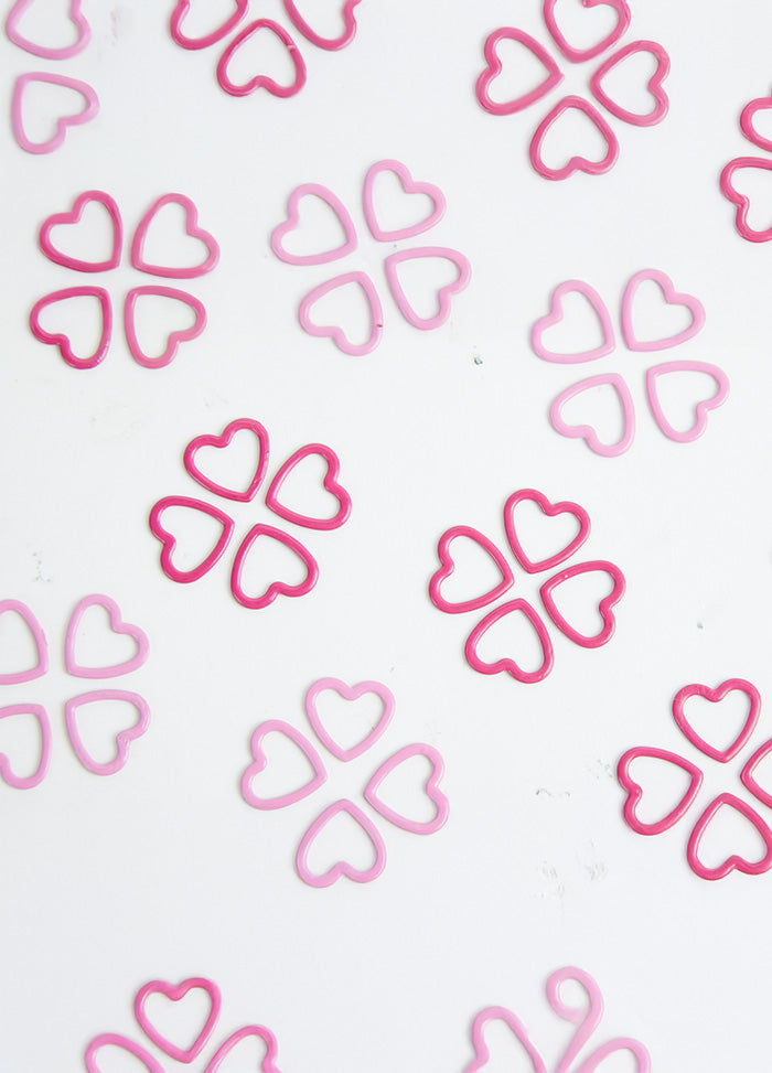 Pink stitch markers arranged on a white surface, part of a 40-pack for the Magnetic Knitter's Necklace Kit.