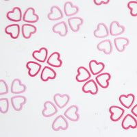 Pink stitch markers arranged on a white surface, part of a 40-pack for the Magnetic Knitter's Necklace Kit.