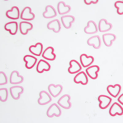 Pink stitch markers arranged on a white surface, part of a 40-pack for the Magnetic Knitter's Necklace Kit.