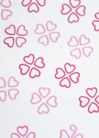 Pink stitch markers arranged on a white surface, part of a 40-pack for the Magnetic Knitter's Necklace Kit.