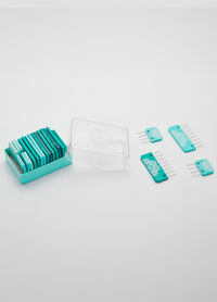 A set of teal knit blockers , some in a clear plastic case and four placed separately on a white surface.