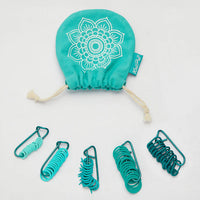 A green bag with green markers inside, representing a neat and attractive assortment of knitting tools.