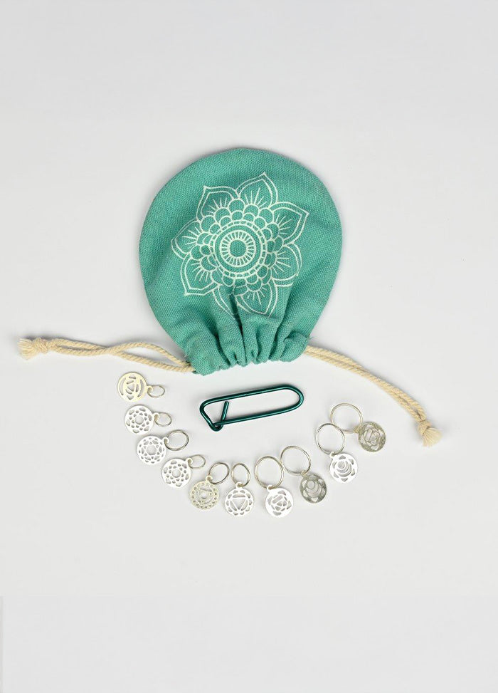 A green bag with a silver coin purse and silver chakra charm set, showcasing fine craftsmanship and a multipurpose pouch.