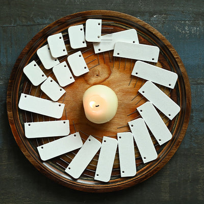 A wooden plate features a candle and knit blockers, creating a warm setting ideal for knitting or crochet projects and relaxation.