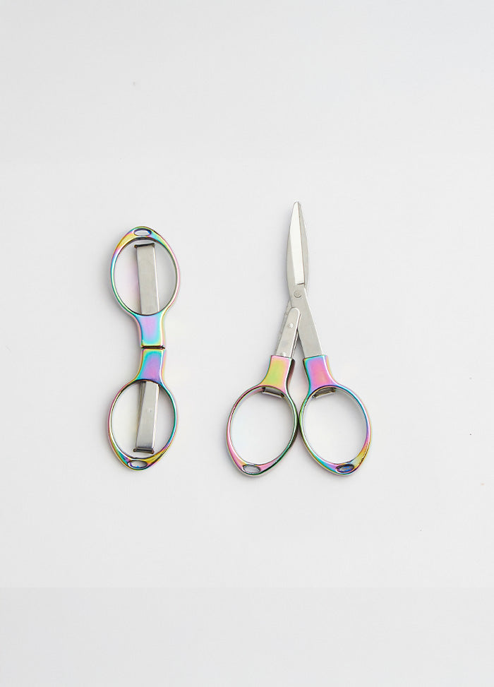 Colourful scissors with a rainbow handle and shiny metal blades, designed to fold for protection from sharp points.