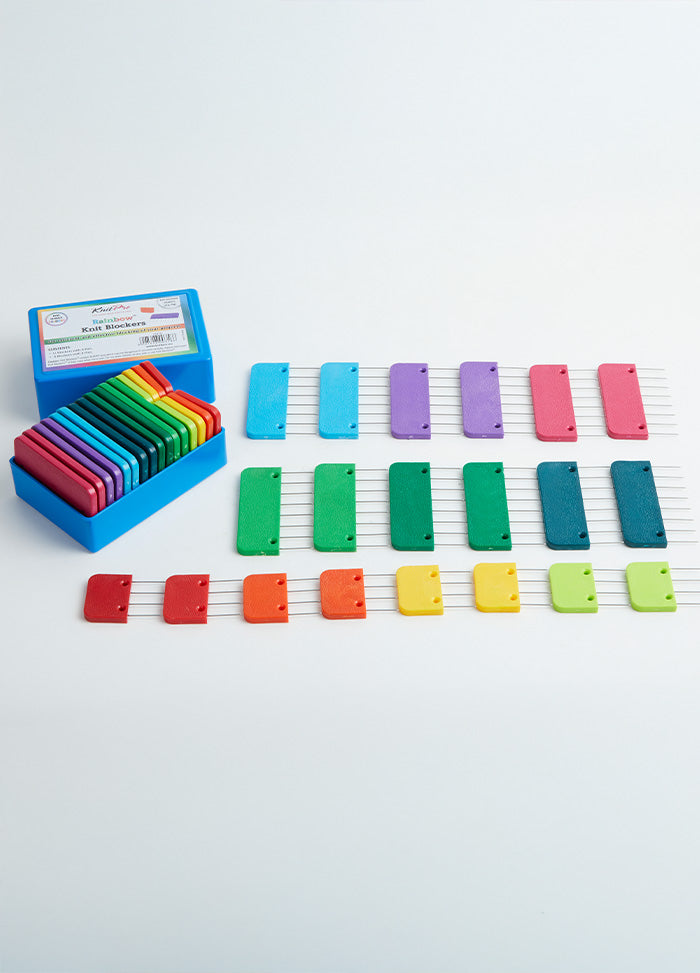 A box containing colorful plastic blocking blocks, designed with stainless steel pins for securing knit and crochet pieces.
