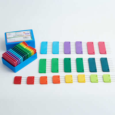 A box containing colorful plastic blocking blocks, designed with stainless steel pins for securing knit and crochet pieces.