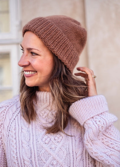 Chloe Beanie: Brown knit hat paired with a textured sweater, styled in a soft outdoor setting.