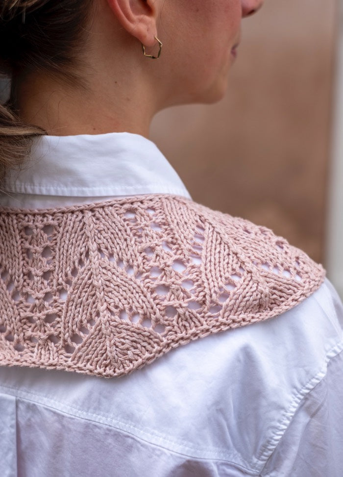 Yours Truly Collar: Pink lace-knit accessory with leaf motifs, styled over a white shirt from the back view.