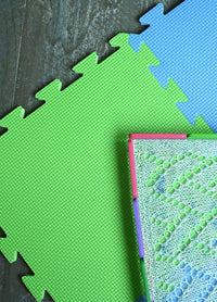 Colorful puzzle mat featuring green and blue pieces, designed for easy assembly and versatile project sizes.