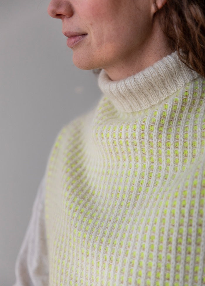 Fonkel Collar: high knitted collar with alternating rows of white and light yellow-green in a textured pattern.