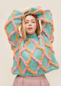 Net Sweater: light blue knit with pink and orange diamond mesh pattern, worn with light pink pants.