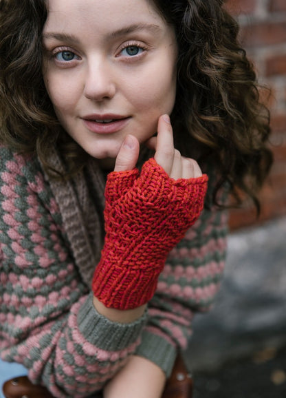 Vaapukka Mitts: red fingerless mitts worn with a pink and green patterned sweater
