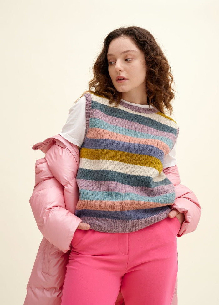 Kreuzberg Vest: colorful striped vest over a white shirt with bright pink pants and a pink puffer jacket