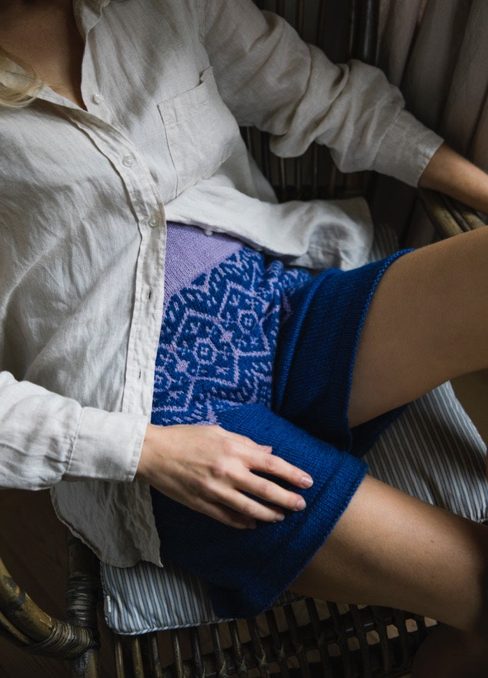 Hielo Shorts: blue knit with geometric pattern, worn seated with white shirt.