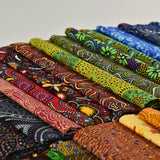 Collection of colorful fabric rolls with intricate patterns on a light gray background