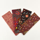 Set of four fabric swatches with Aboriginal patterns on a white background