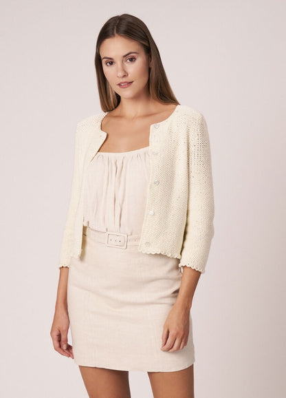 Textured knit vest with deep armholes, layered over a sleeveless top.