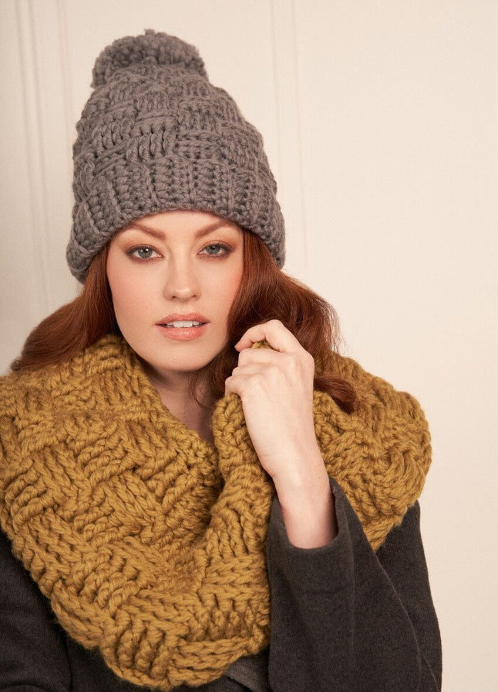 Close-up of a crochet beanie and cowl in thick wool, featuring ribbed brim and snug fit.