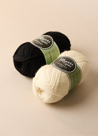 Two balls of Morris Brand yarn, 100% wool, perfect for crafting homewares or slippers, shown with labels in a rustic setting.