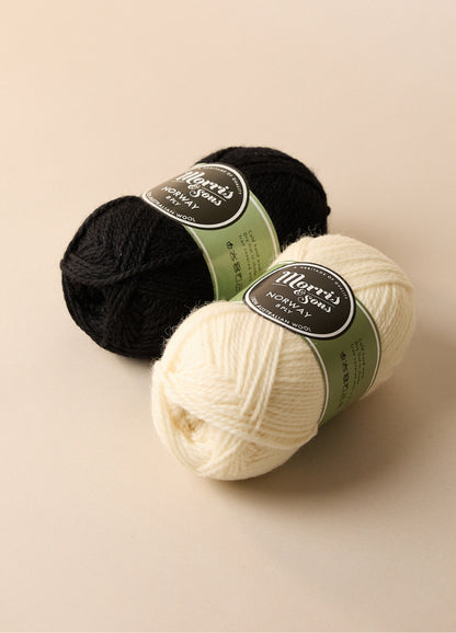 Two balls of Morris Brand yarn, 100% wool, perfect for crafting homewares or slippers, shown with labels in a rustic setting.