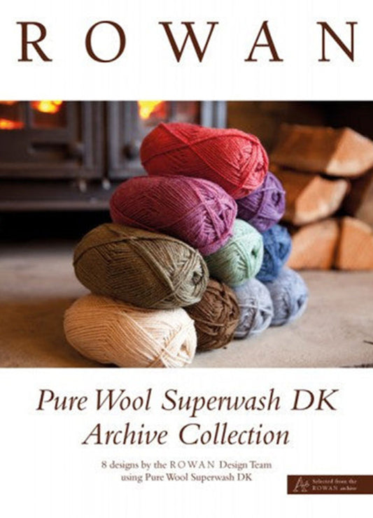 Stacked colorful yarn balls in red, purple, green, and beige in front of a cozy fireplace. Text: "Rowan Pure Wool Superwash DK Archive Collection." Warm ambiance.