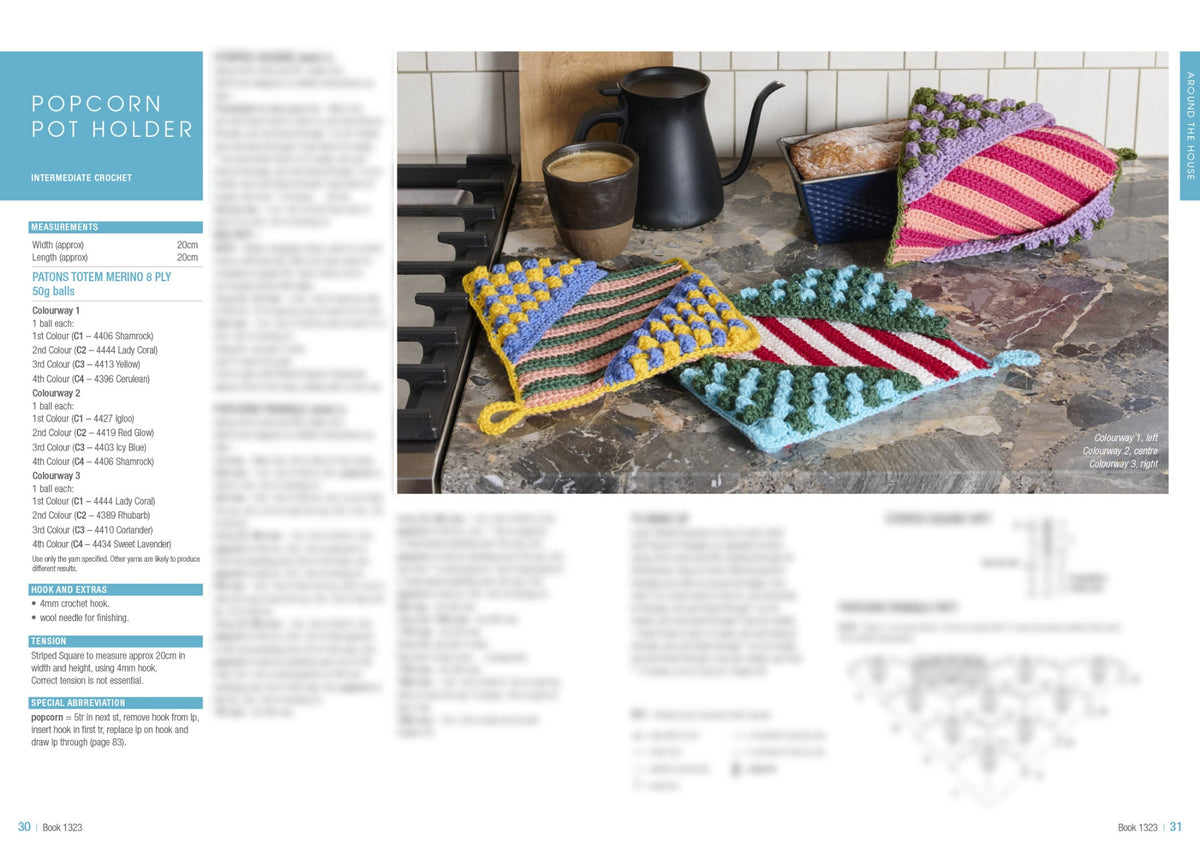 Colorful crocheted pot holders with popcorn stitches sit on a kitchen counter next to a mug and kettle. Cozy and handmade vibe.