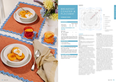 Breakfast setting with crocheted placemats and coasters adorned in orange and blue tones. Two bowls with apricots and cream, colorful glass cups, and a floral centerpiece create a cozy, inviting atmosphere.