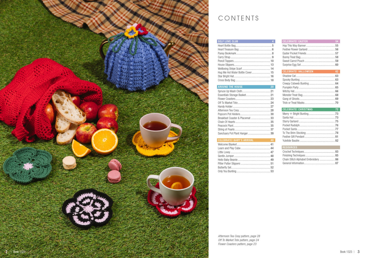 Cozy picnic setup on grass with tea in cups on crocheted coasters. A red bag holds bread and fruit. A blue teapot cozy sits on a plaid blanket.