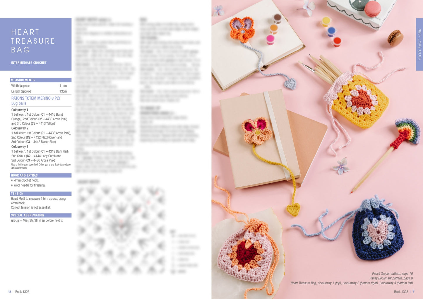 Crocheted heart bags and decorations on a pastel pink surface with notebooks, colored pencils, and macarons, conveying a playful, creative vibe.