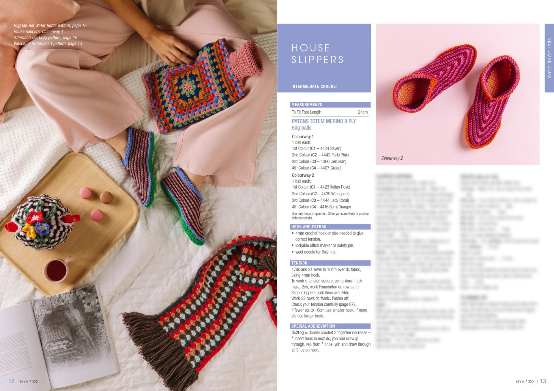 A cozy scene with a person in pink pants lounging on a bed, wearing colorful crocheted slippers. A wooden tray with yarn and macaroons is nearby. A crocheted scarf and an open book complete the setting.