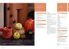 Festive Halloween scene with knitted pumpkins and treat baskets on a fireplace. Plastic spiders adorn the wall, and a paper pumpkin adds charm.