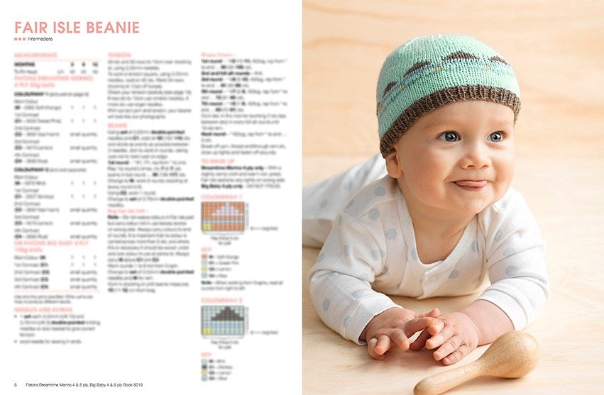 A baby in a polka dot onesie smiles while wearing a knitted teal and brown Fair Isle beanie. A wooden rattle lies near the baby. Pattern instructions are displayed to the left.