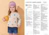 Young child smiling, wearing a colorful polka dot sweater and beanie, holds a yellow ball. Pattern instructions are visible beside her on a white panel.