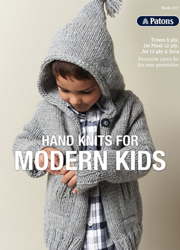 A child in a cozy grey knitted hoodie with a pointed hood focuses on their sleeve. The text reads "Hand Knits for Modern Kids" by Patons. The tone is warm and playful.