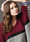 Young woman in a burgundy, black, and gray color-block sweater. Her expression is calm, arm resting on head. The Patons knitting brand logo is visible.